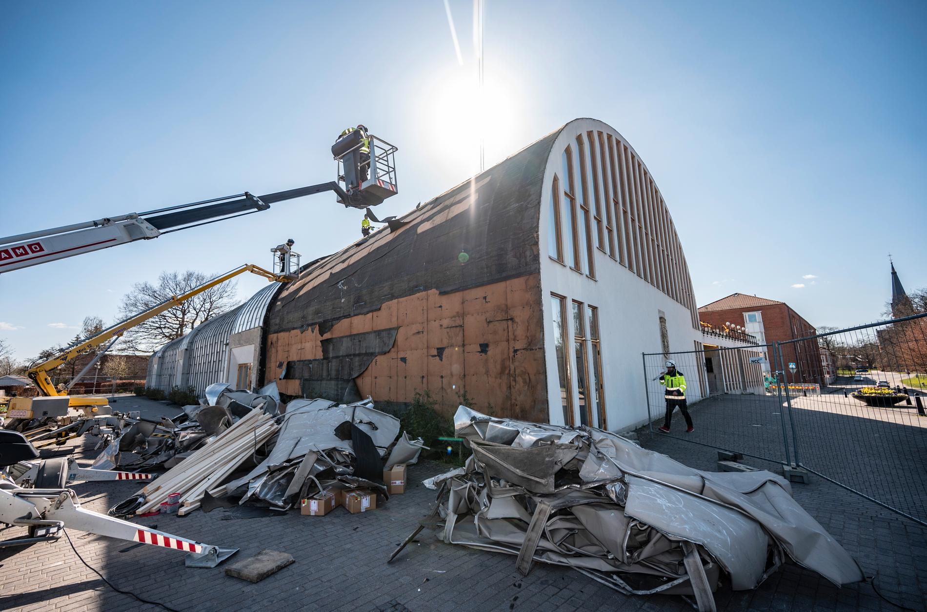 Arbete pågår med att säkra upp taket som blåst av Medborgarhuset i Eslöv i de hårda vindbyarna på torsdagen. Byggnaden som invigdes 1957 är ritad av arkitekten Hans Asplund.
