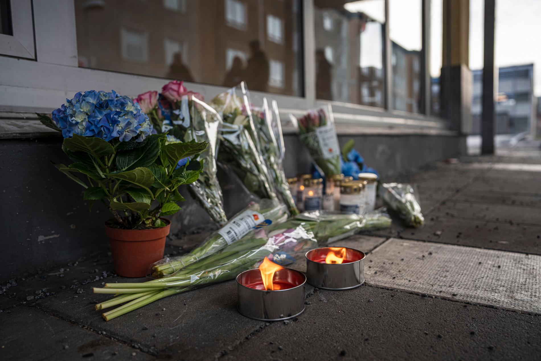 En minnesplats med blommor och ljus i Skogås centrum, dagen efter mordet.
