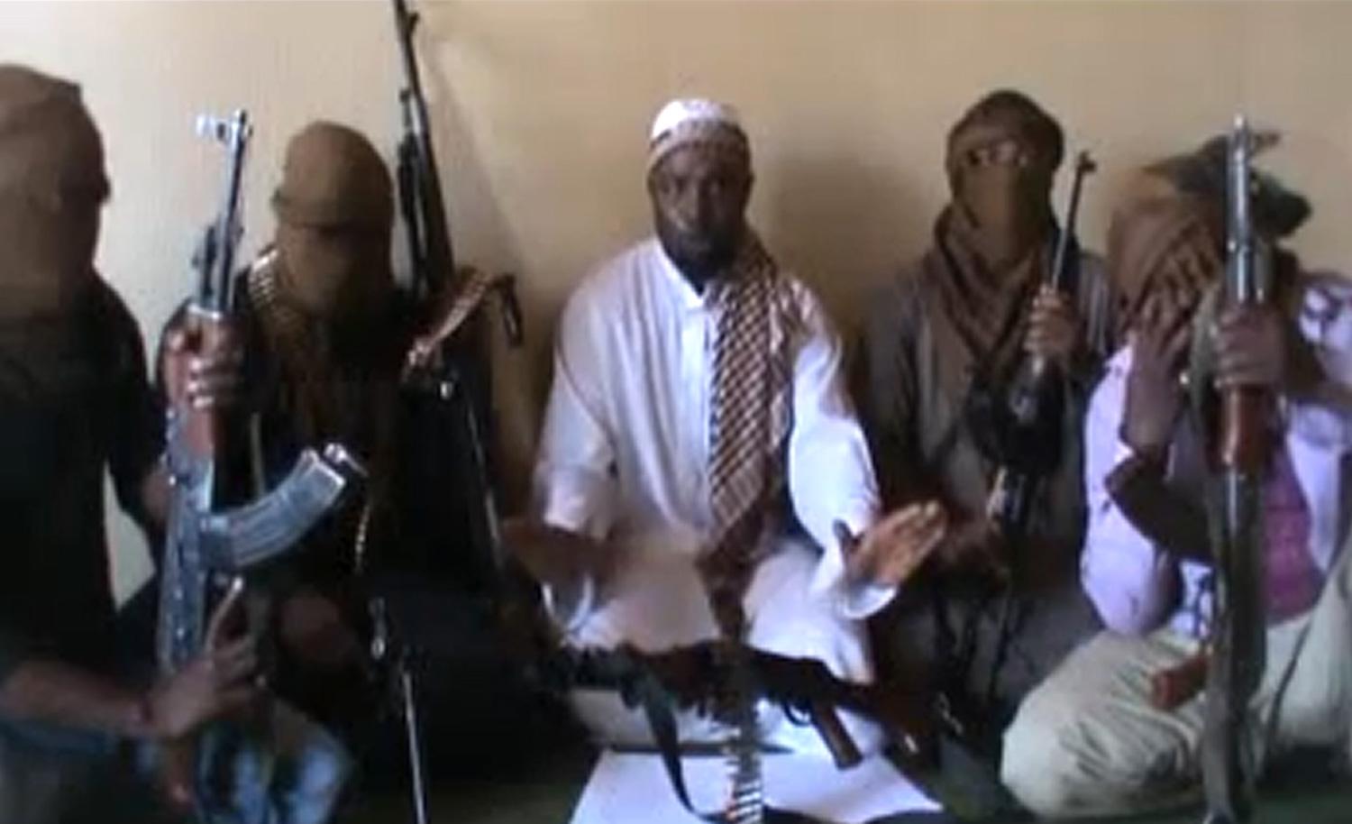 Skärmdump från ett youtubeklipp med Boko Harams ledare Abubakar Shekau omgiven av maskerade medhjälpare.