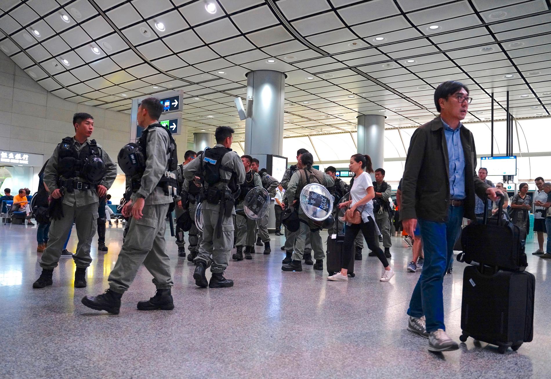 Polis vaktar på flygplatsen i Hong Kong.