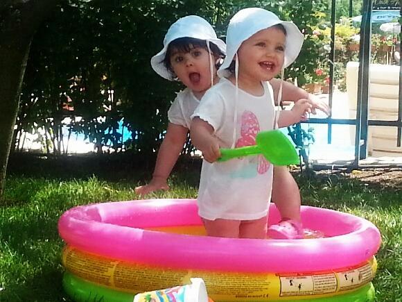 Tvillingarna Alice och Estelle, 16 månader, tar ett dopp i poolen