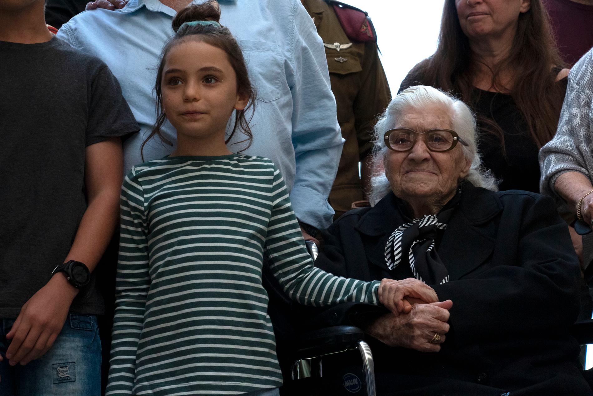 Melpomeni Dina håller en israelisk flicka i handen vid återföreningen med de judiska syskon som hon räddade under andra världskriget.