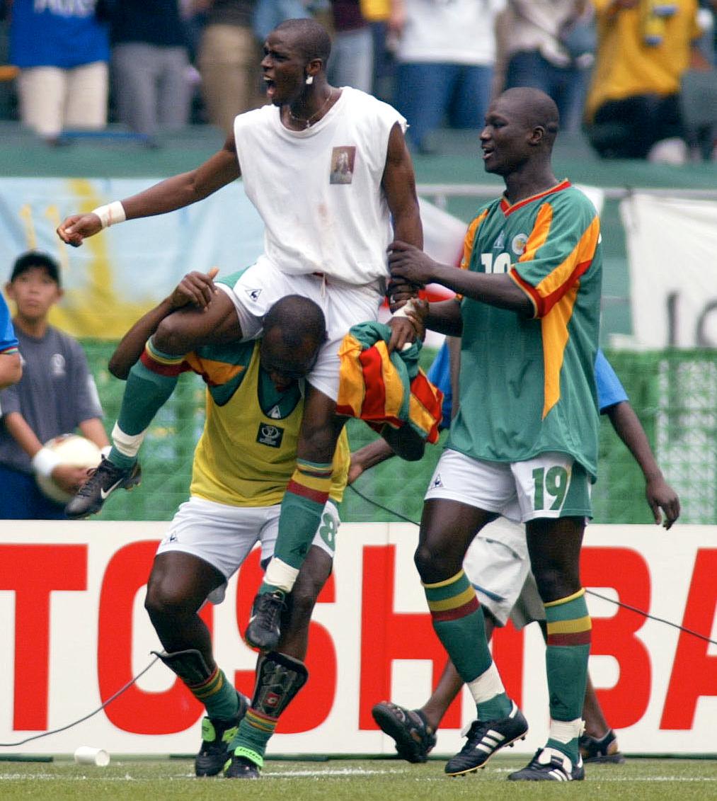 Papa Bouba Diop med och firar Henri Camara, som med sitt mål i förlängningen slog ut Sverige ur VM 2002.