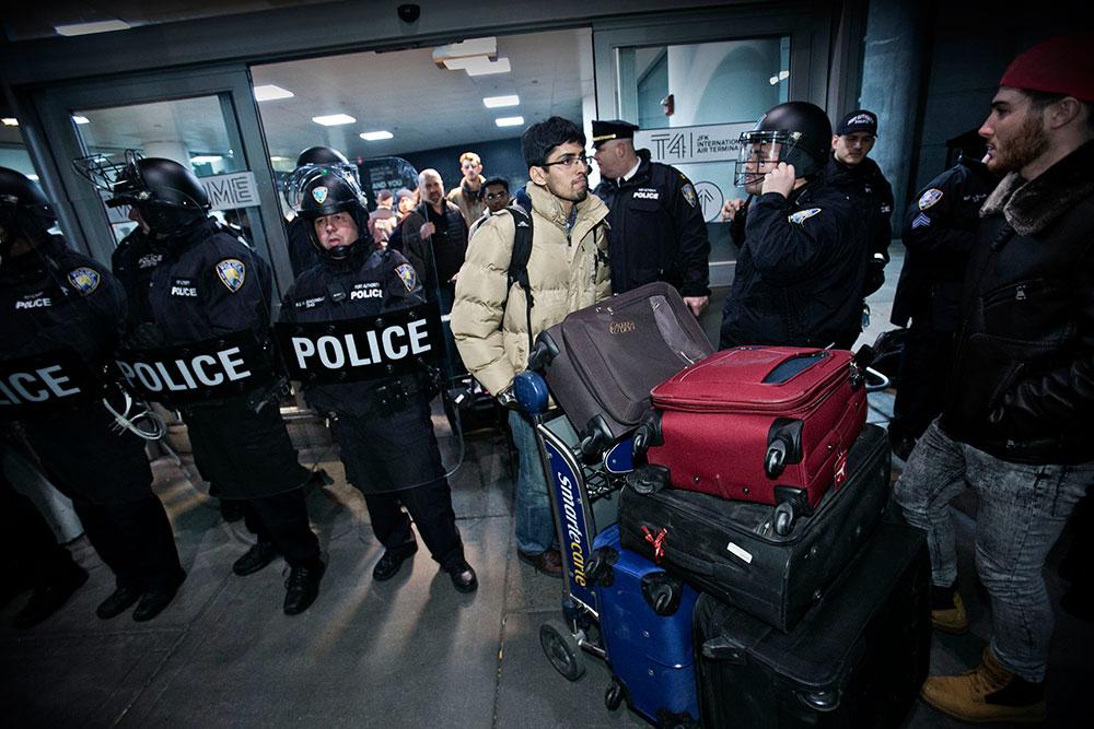 Kravallpoliser beväpnade med batonger vaktade så att bara resenärer med biljetter kunde komma in i JFK-flygplatsen.