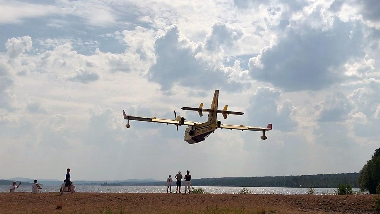 Ett italienskt brandflygplan skopar upp vatten från Orrmosjön i Härjedalen.