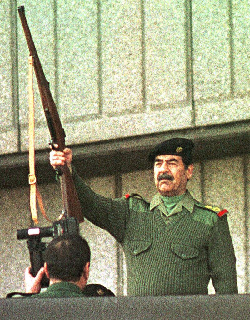 Saddam Hussein avfyrar ett gevär som inledning på firandet av ”Quds stora dag”.