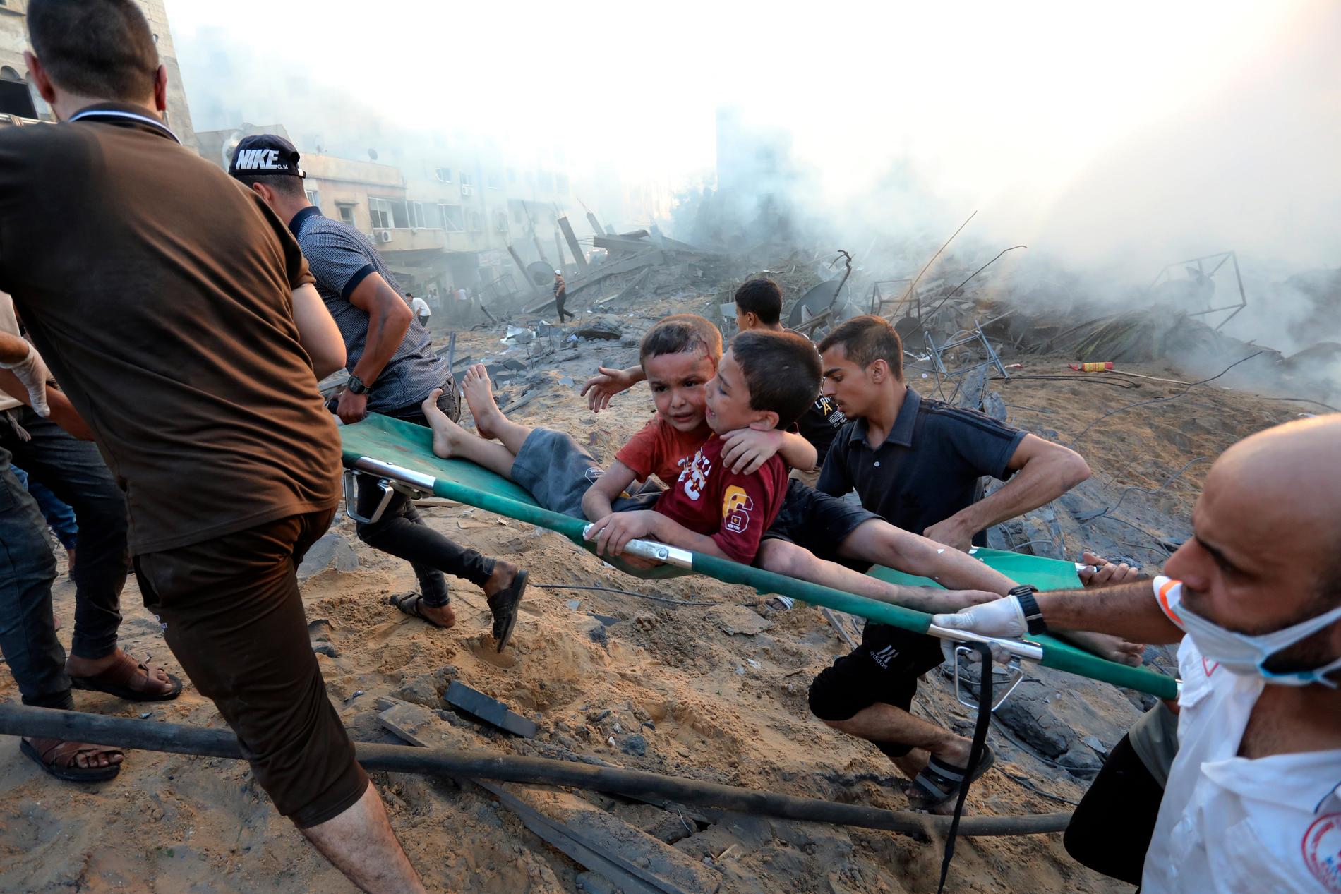 Två skadade pojkar bärs på en bår efter flygattacker mot Gaza, den 25 oktober, 2023.