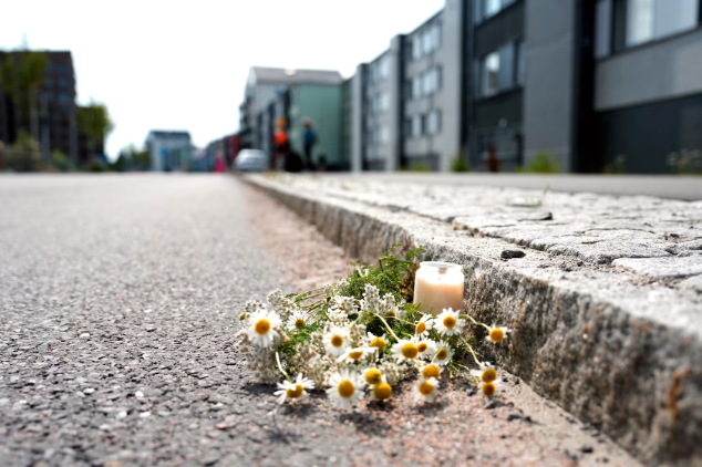 En blomma och ett ljus syns på platsen där kvinnan föll offer för attacken.