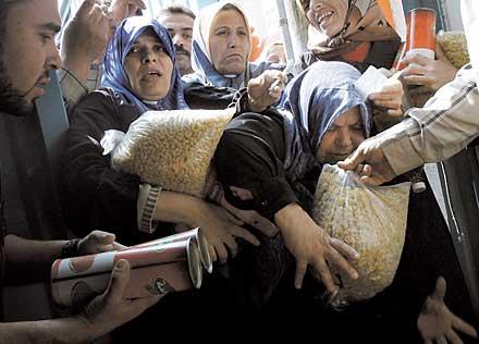 Det är inte Hamas-ledarna som drabbas av omvärldens sanktioner, det är det hårt prövade palestinska folket. Kvinnorna trängs för att få påsar med makaroner och konservburkar som biståndsarbetare delar ut i Gaza City.