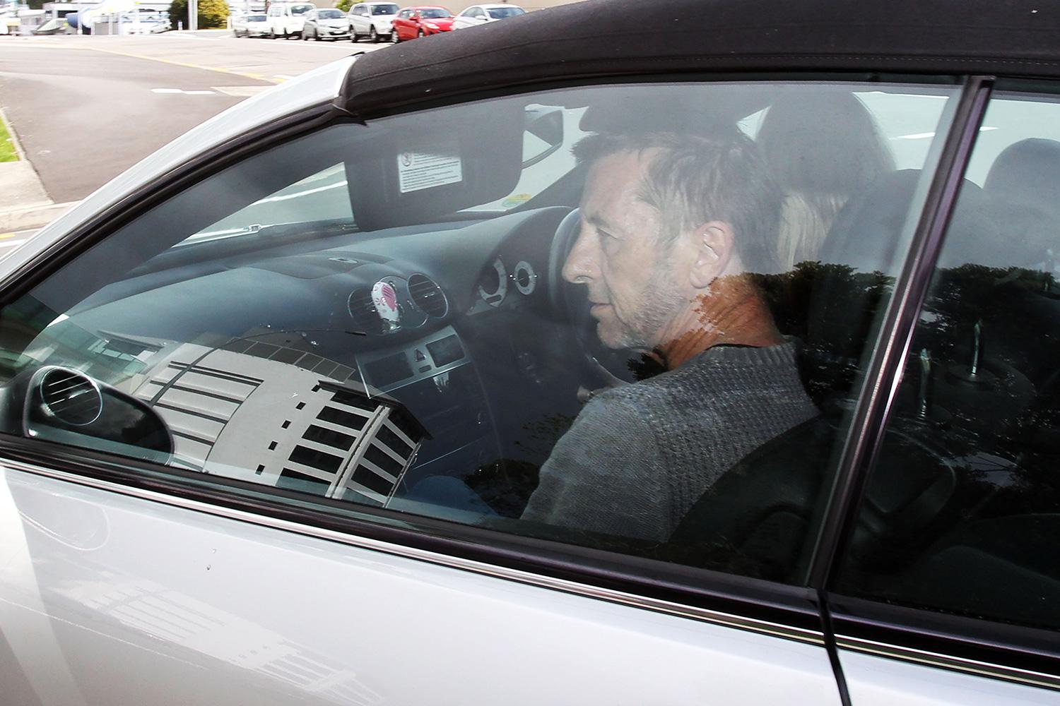 Phil Rudd i bilen på väg från häktet.