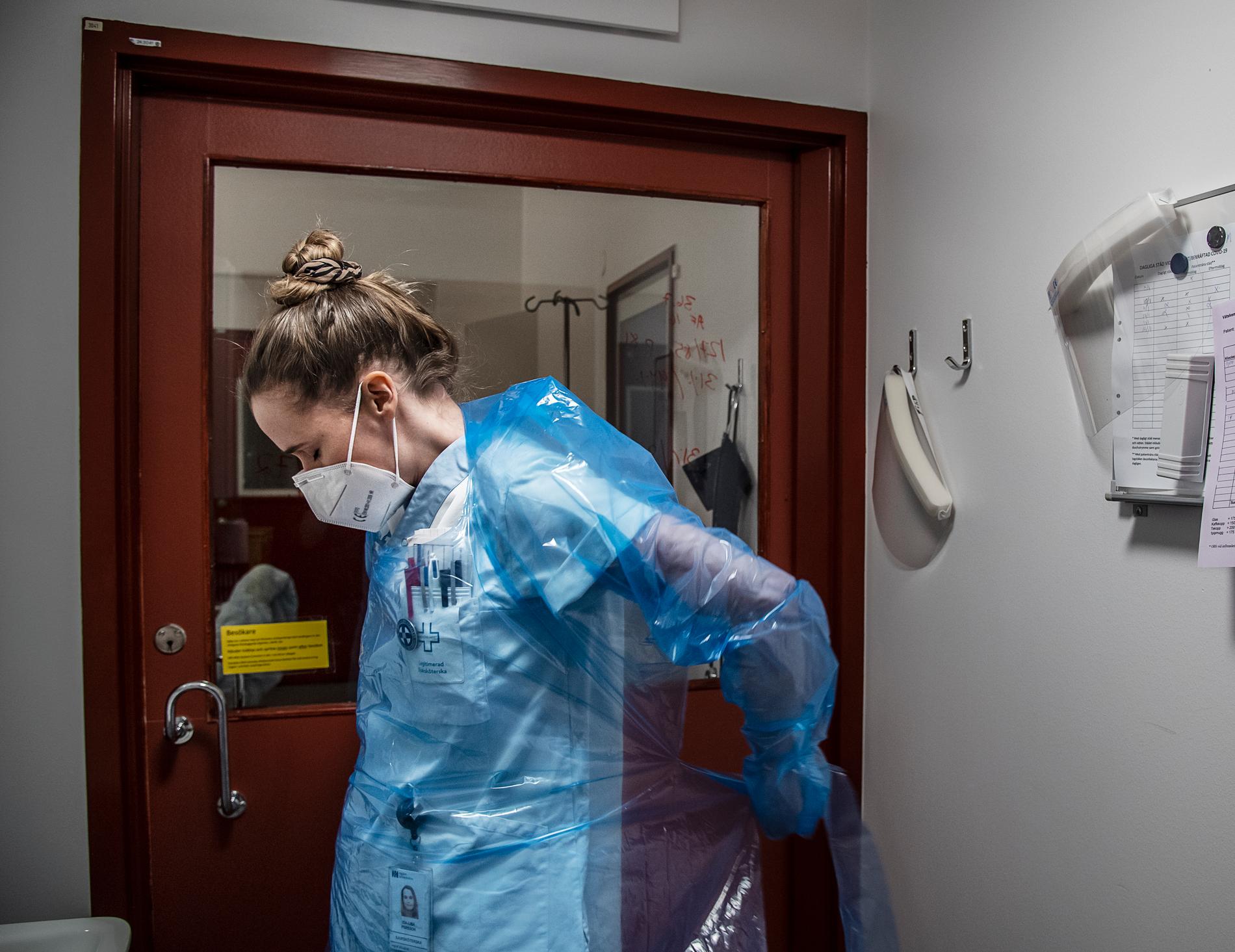 Sjuksköterskan Ida-Lisa Persson, 31 år, klär på sig skyddskläder för att gå in till patient med covid-19 på infektionskliniken.