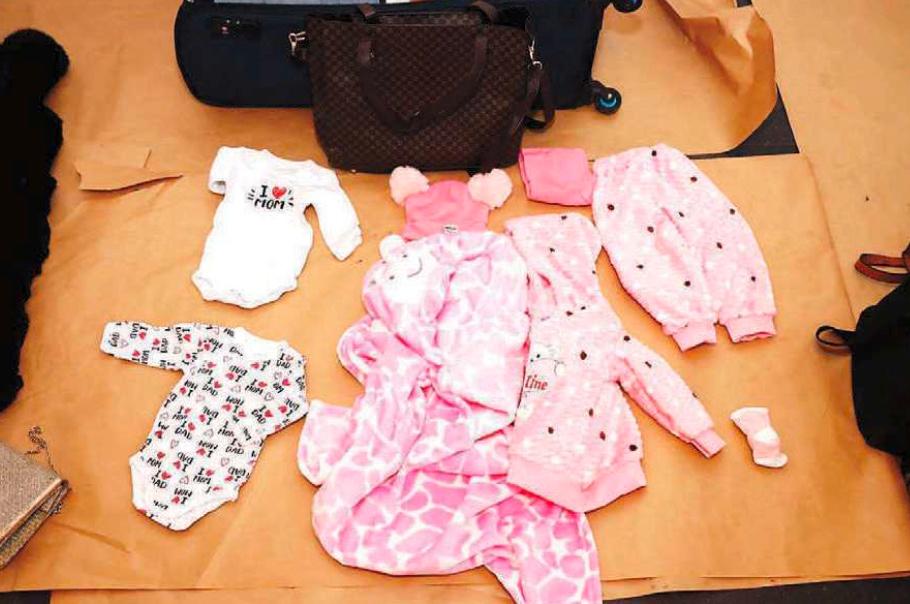Blandat med Carines kläder låg i resväskan en bebisbody med texten ”I love mom” och flera andra rosa och vita babykläder till den ofödda dottern.