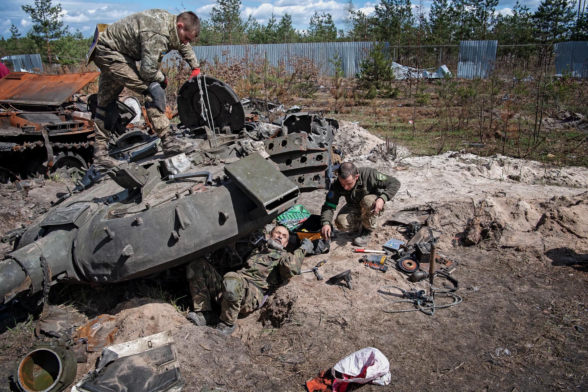 Petro och hans kollegor i ukrainska militären plockar ut reservdelar från utbrända ryska stridsvagnar. 