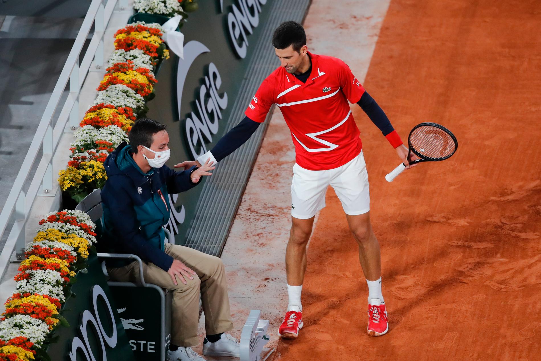 Världsettan Novak Djokovic kollar av läget med den linjedomare han råkade träffa med en boll i segermatchen mot ryssen Karen Chatjanov.