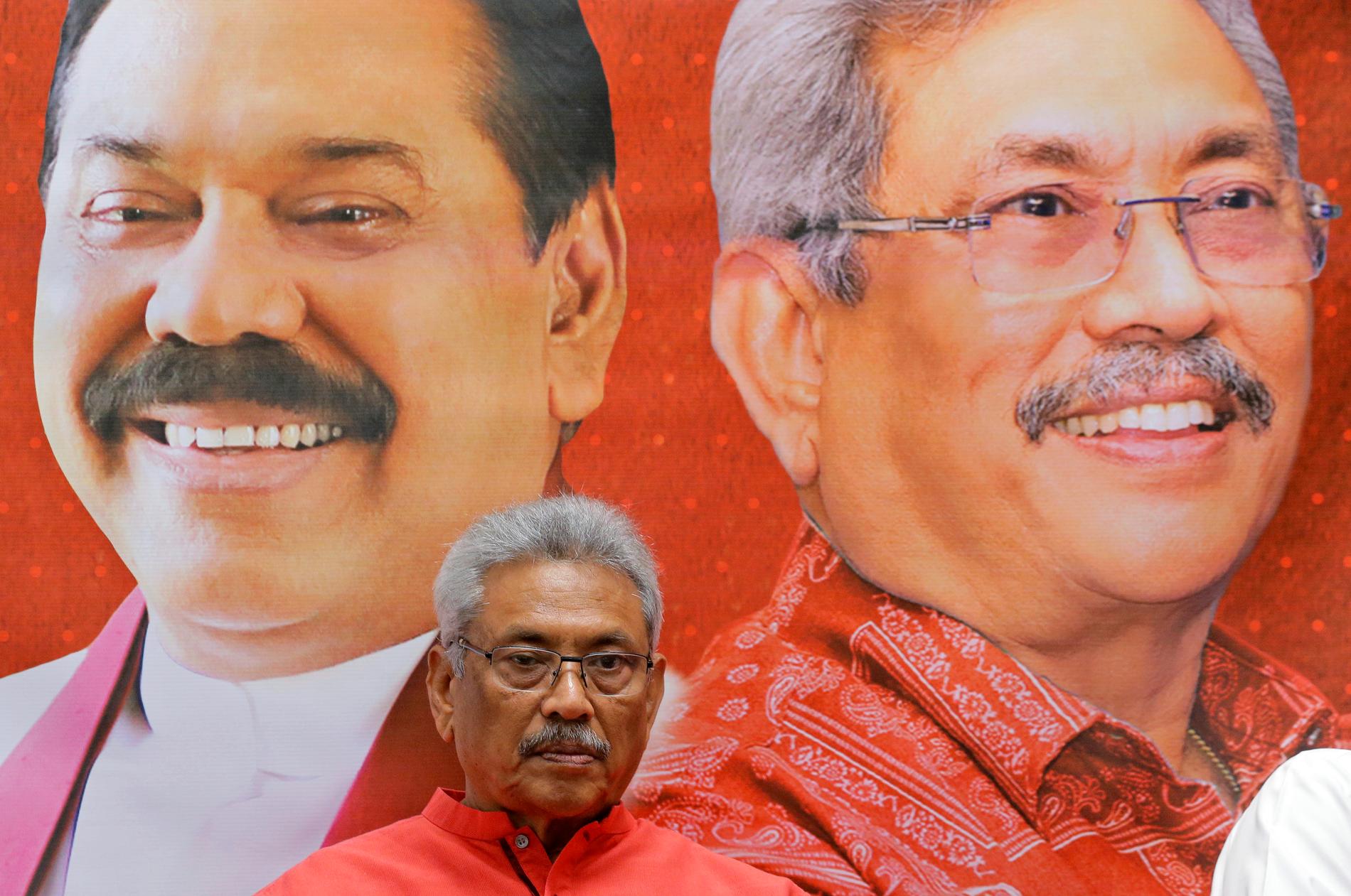 Gotabaya Rajapaksa, som vann presidentvalet, framför en affisch med porträtt på honom och hans bror Mahinda Rajapaksa. Arkivbild.