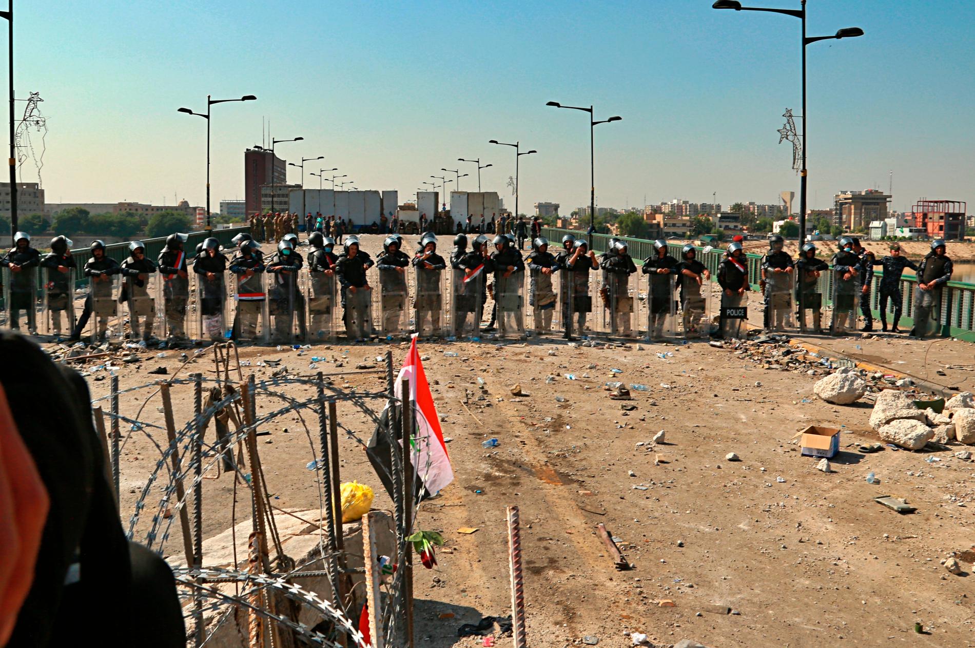 Säkerhetsstyrkor står vakt på en bro som leder till regeringskvarteren i den gröna zonen i Bagdad.