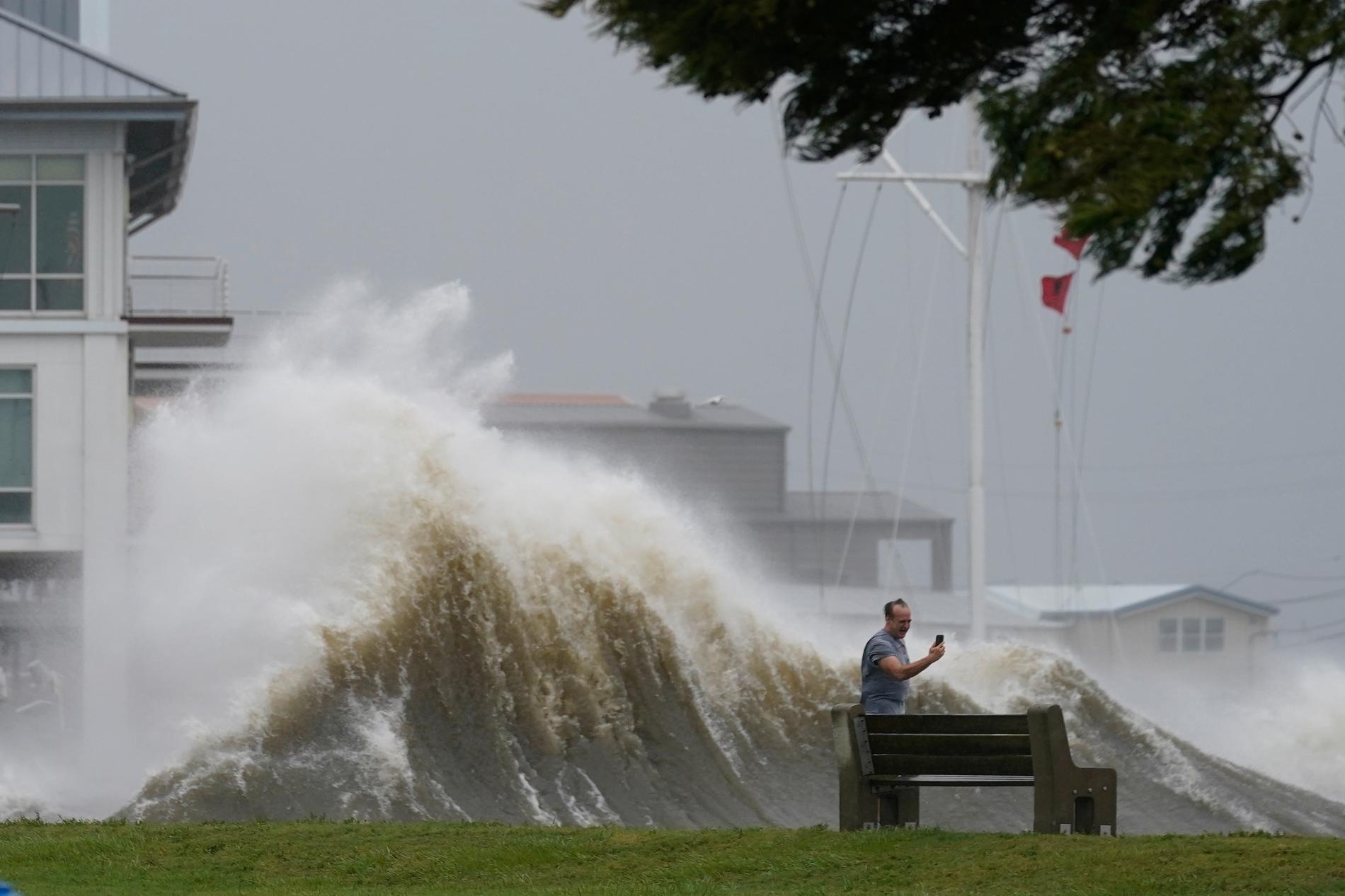 En man tar en selfie medan höga vågor slår mot flodmynningen Lake Pontchartrain i sydöstra Louisiana.