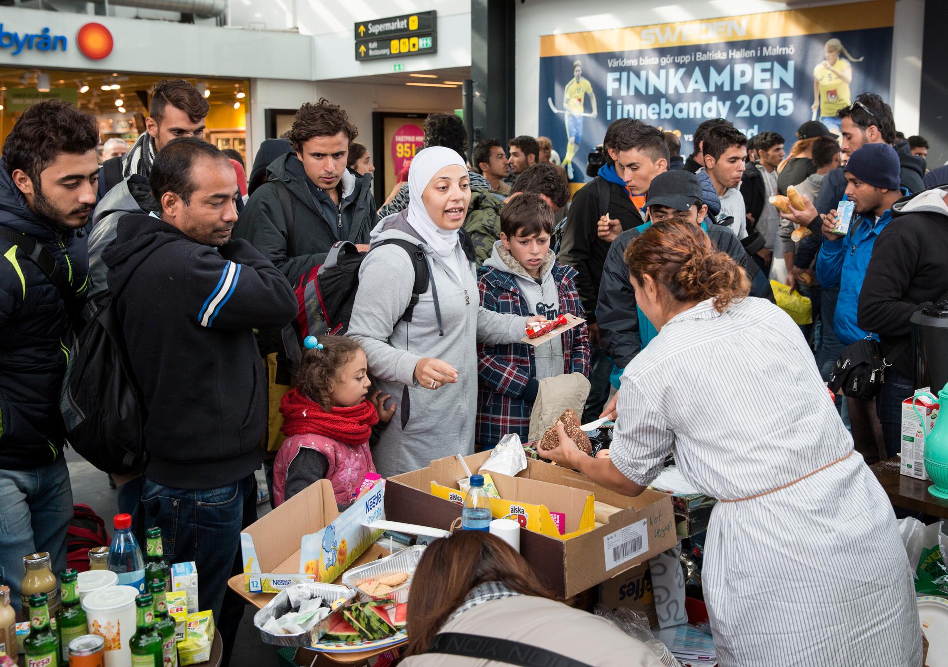 Matutdelning till flyktingar på Malmö centralstation på torsdagen. Flyktingar måste vara välkomna i Sveriges alla kommuner, skriver debattörerna.