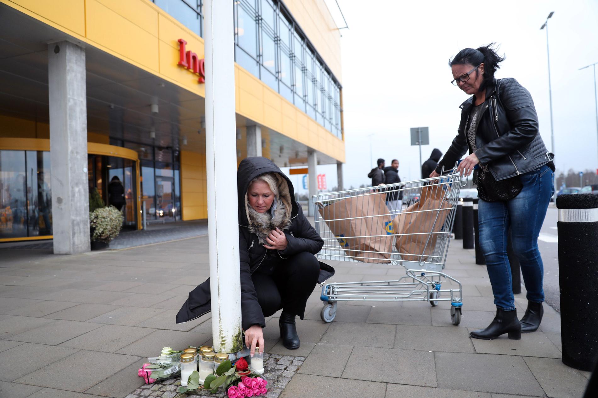 Kunder tänder ett ljus och lämnar blommor vid Ikea i Älmhult.
