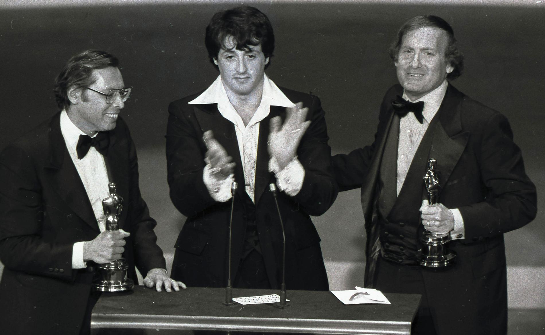 Robert Chartoff (höger) och producentkollegan Irwin Winkler (vänster) tar emot Oscarstatyetten för "Rocky" tillsammans med Sylvester Stallone 1976.