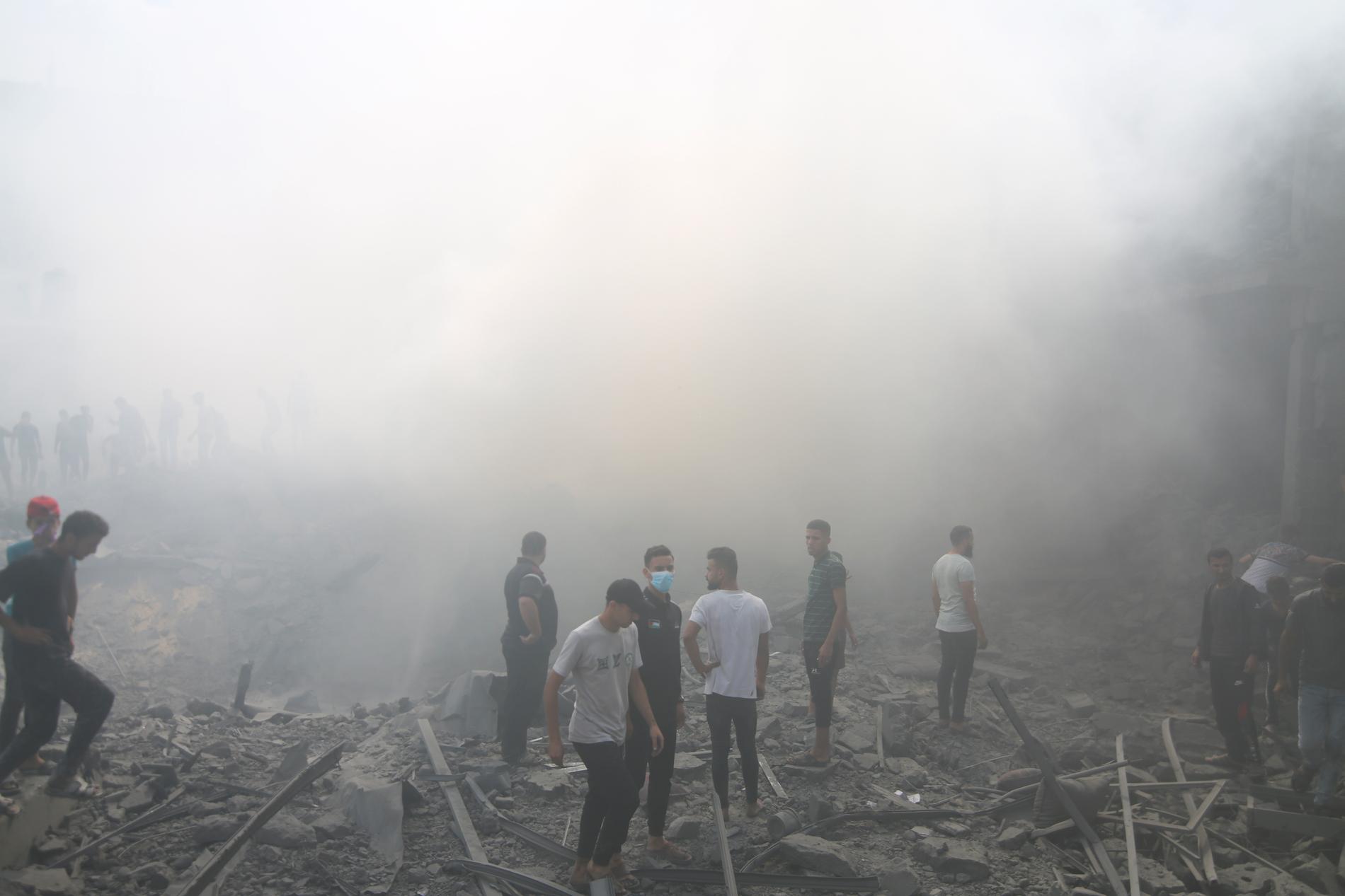 Palestinier letar efter överlevande efter en israelisk flygattack i flyktinglägret i Rafah, södra Gazaremsan.