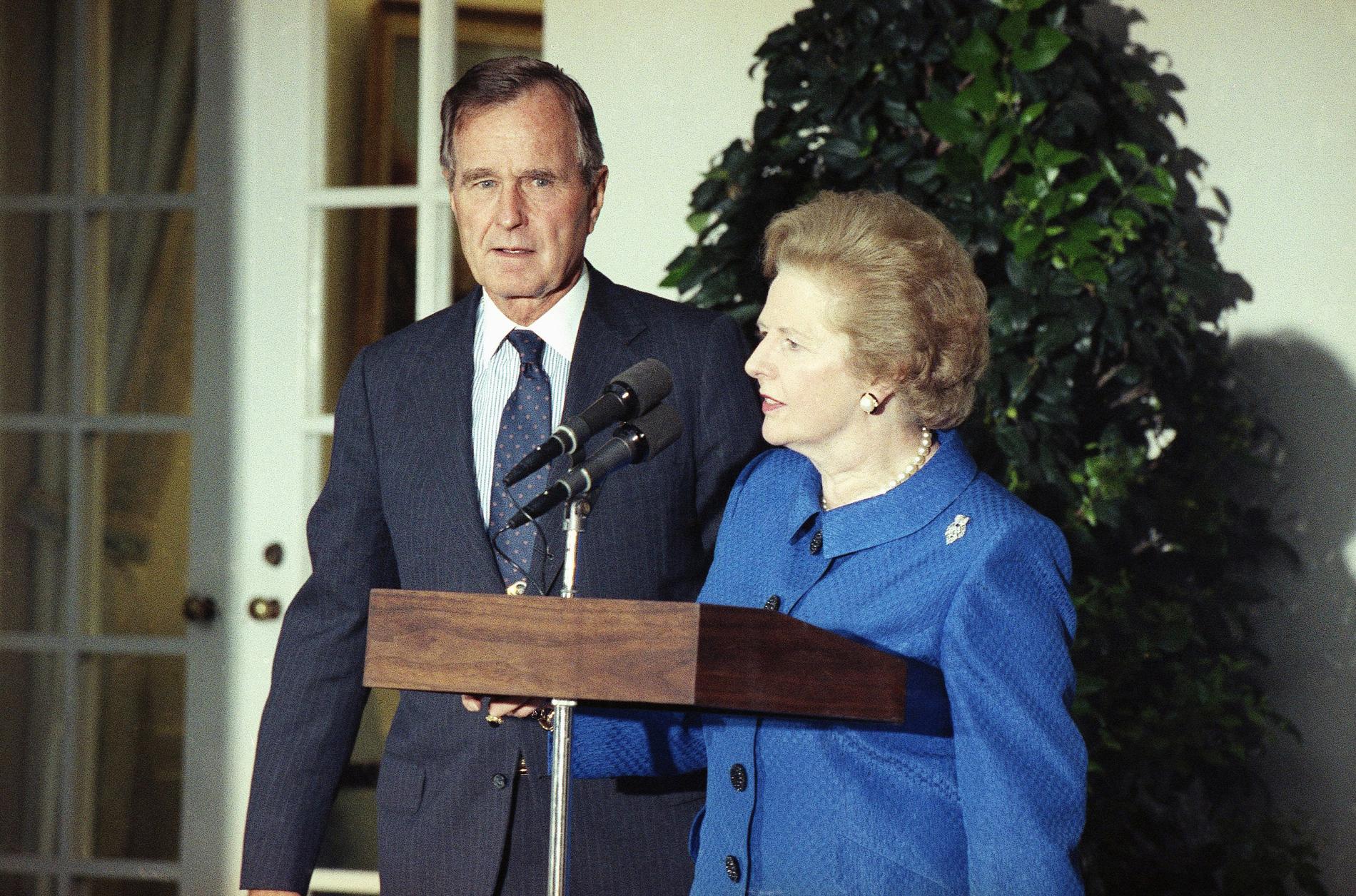 British Prime Minister Margaret Thatcher, with President Bush looking on, speaks to reporters, Monday, August 7, 1990 in Washington in the White House Rose Garden after an Oval Office meeting on the situation in the Persian Gulf. The United Nation Security Council voted 13-0 in favor of strict economic sanctions against Iraq.
