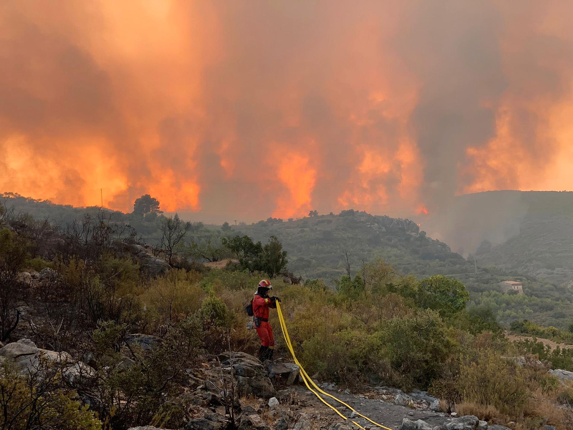 Militär nödenhetspersonal arbetar för att släcka en skogsbrand i Useres, östra Spanien, augusti 2022.