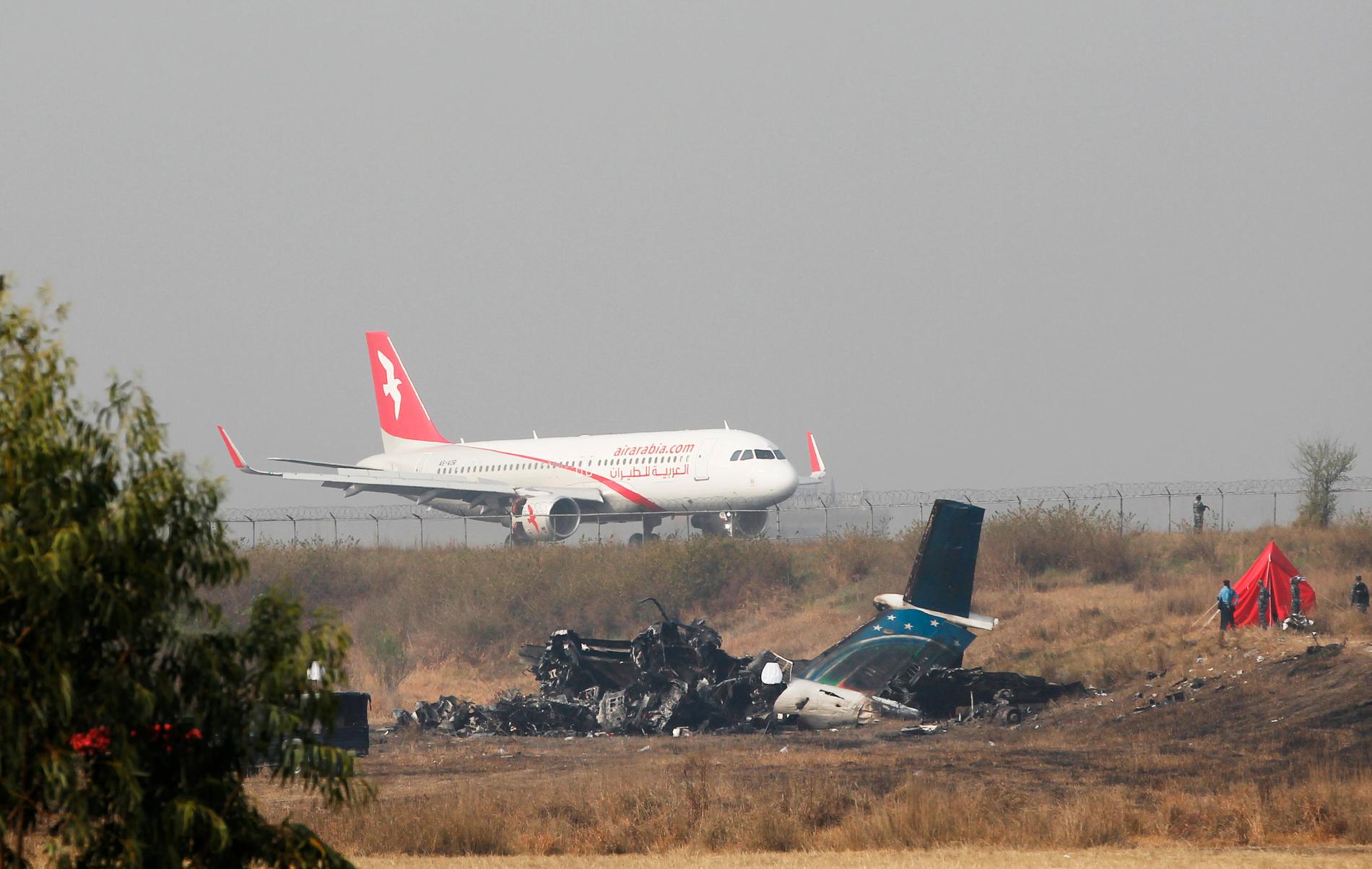 Det utbrunna US-Bangla-flygplanet bredvid landningsbanan i Nepal den 13 mars 2018, dagen efter kraschen.