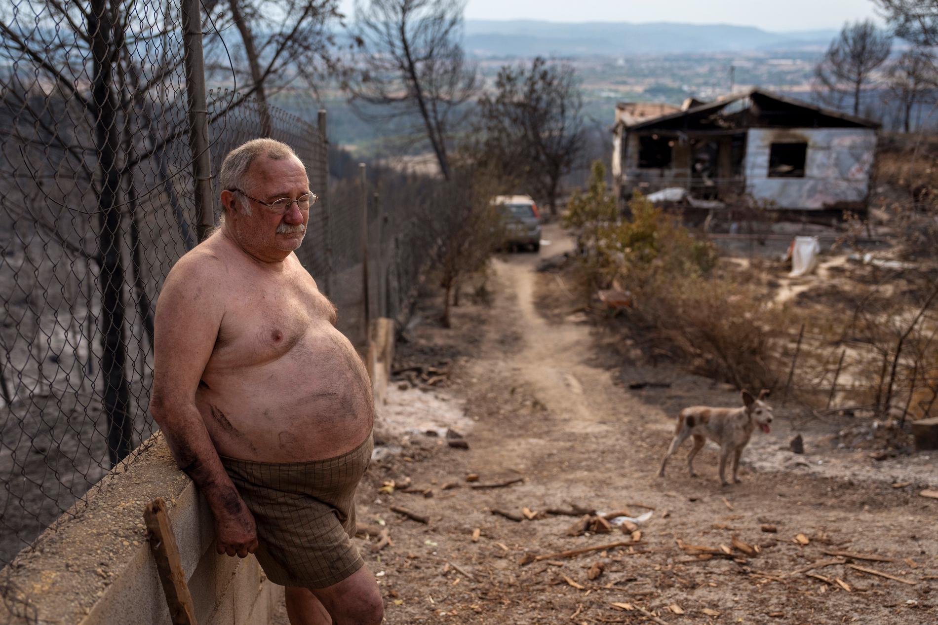 Jordi Villalta, 62, står bredvid sitt hus som förstördes av en skogsbrand i byn River Park i Spanien i slutet av juli. ”Jag förlorade allt, det jag har på mig är allt jag har kvar”, berättar han. Under sommaren har extrema temperaturer uppmätts i Spanien,  med torka och bränder som följd. 