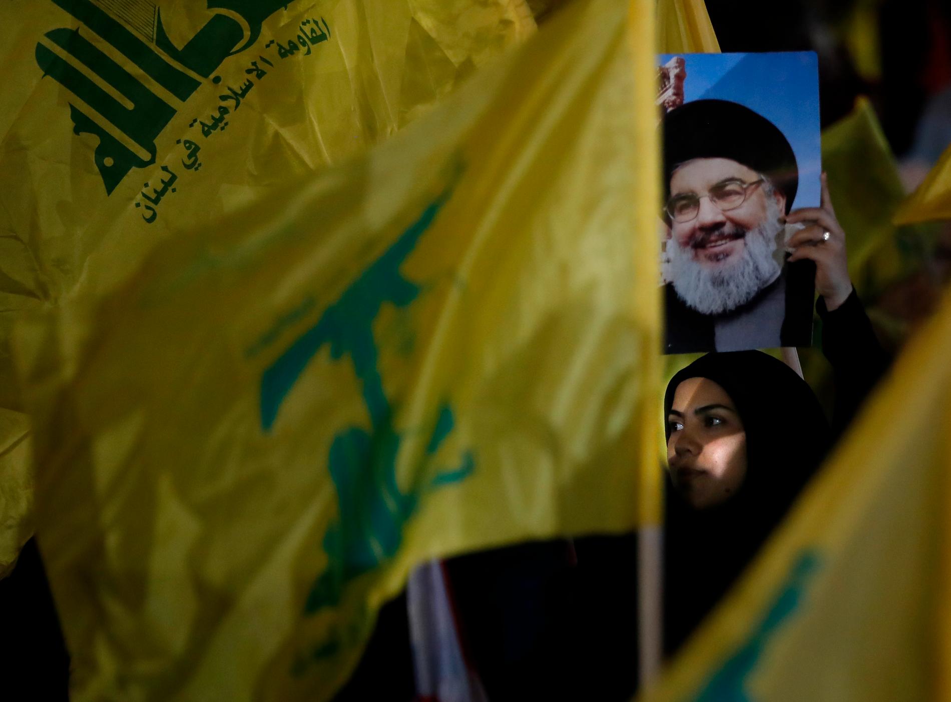 En Hizbollah-anhängare bär ett porträtt av rörelsens ledare Hassan Nasrallah, vars son nu terrorlistas i USA. Arkivbild från augusti.