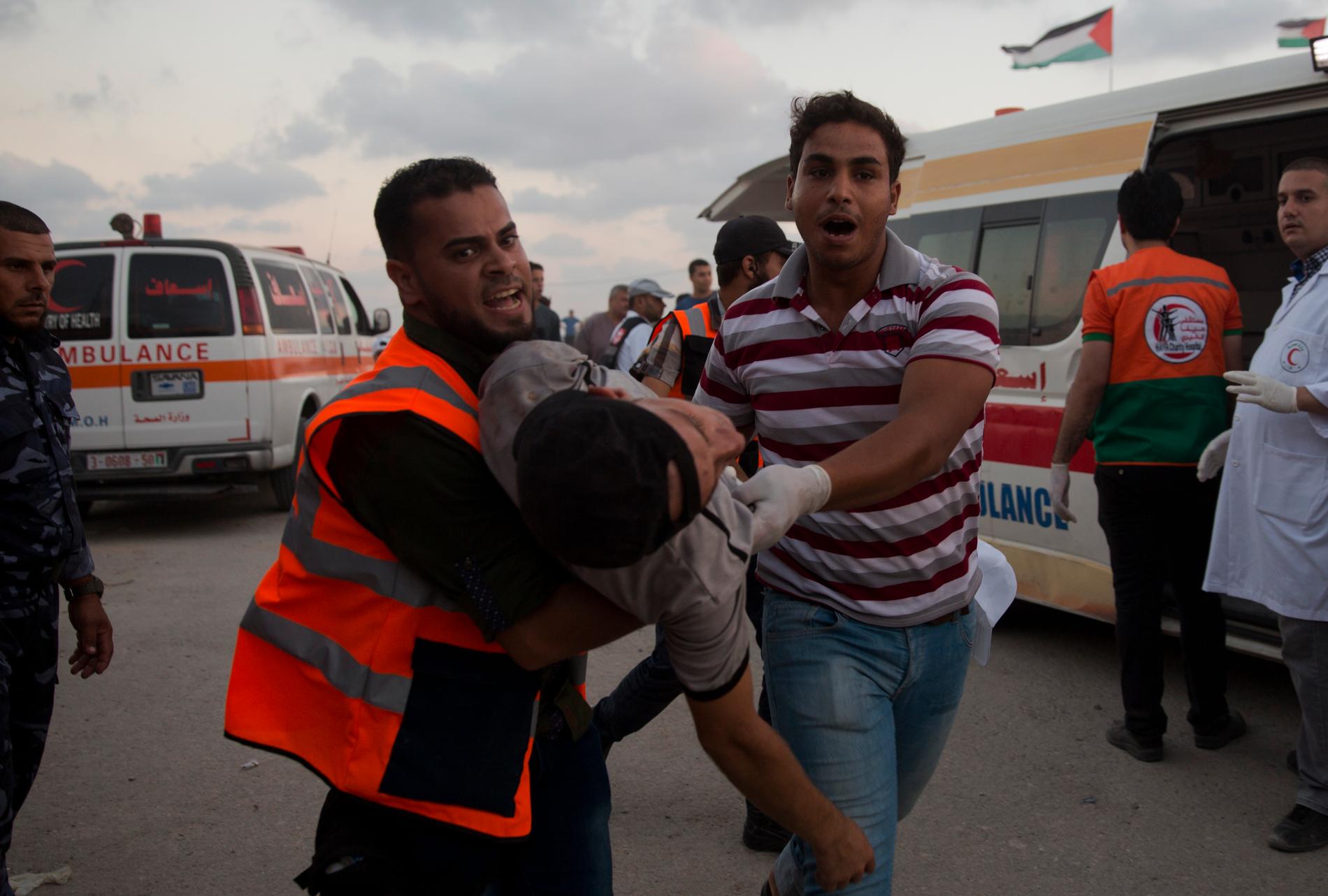 Sjukvårdare i Gaza bär en skadad man, som träffats av israelisk beskjutning, till ett fältsjukhus.