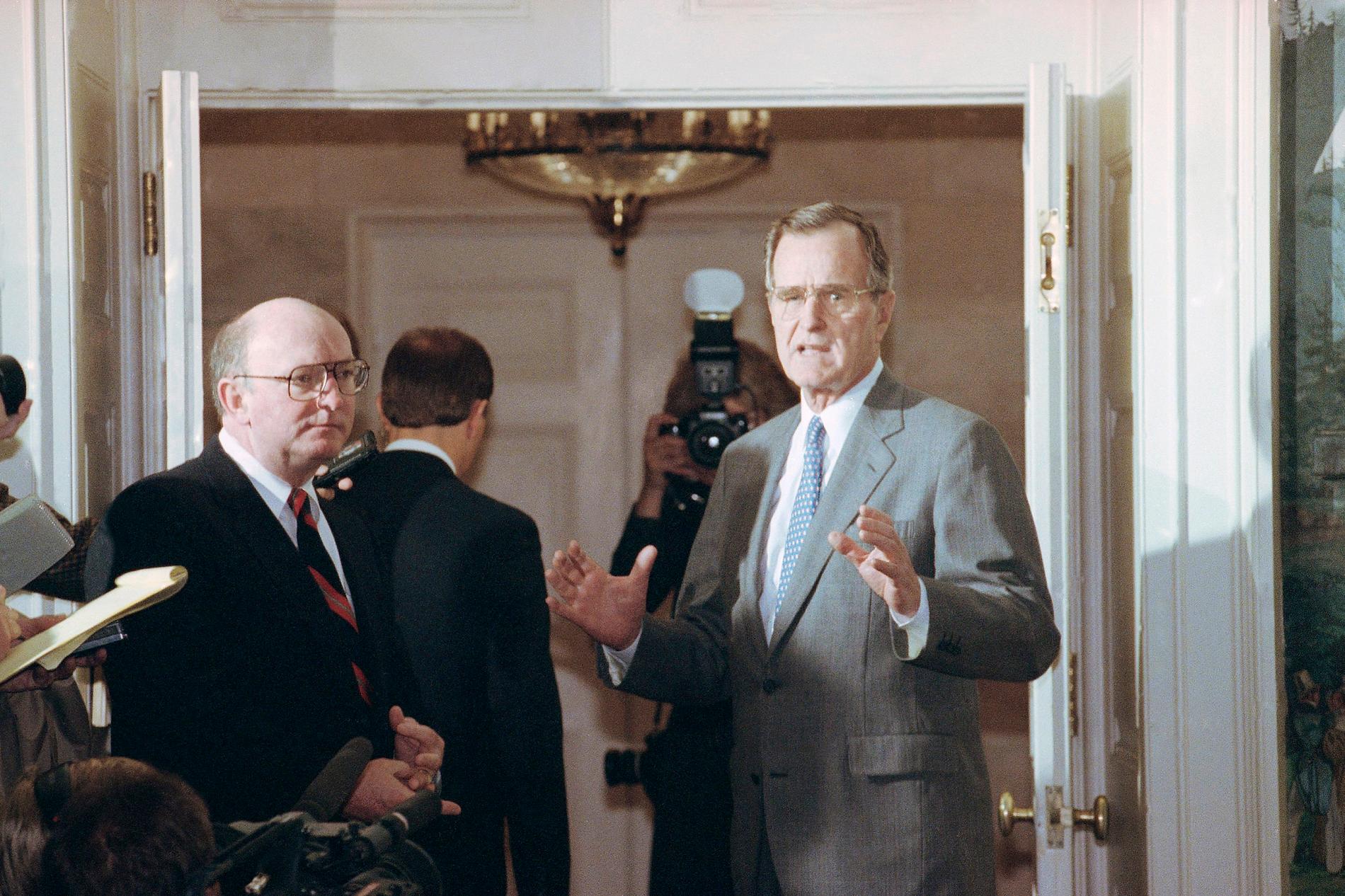 George H. W. Bush, center, responds to reporters at the White House saying he sent a personal message to Soviet President Mikhail Gorbachev to make sure the Soviets understand our position on Lithuania, Friday, March 30, 1990, Washington, D.C