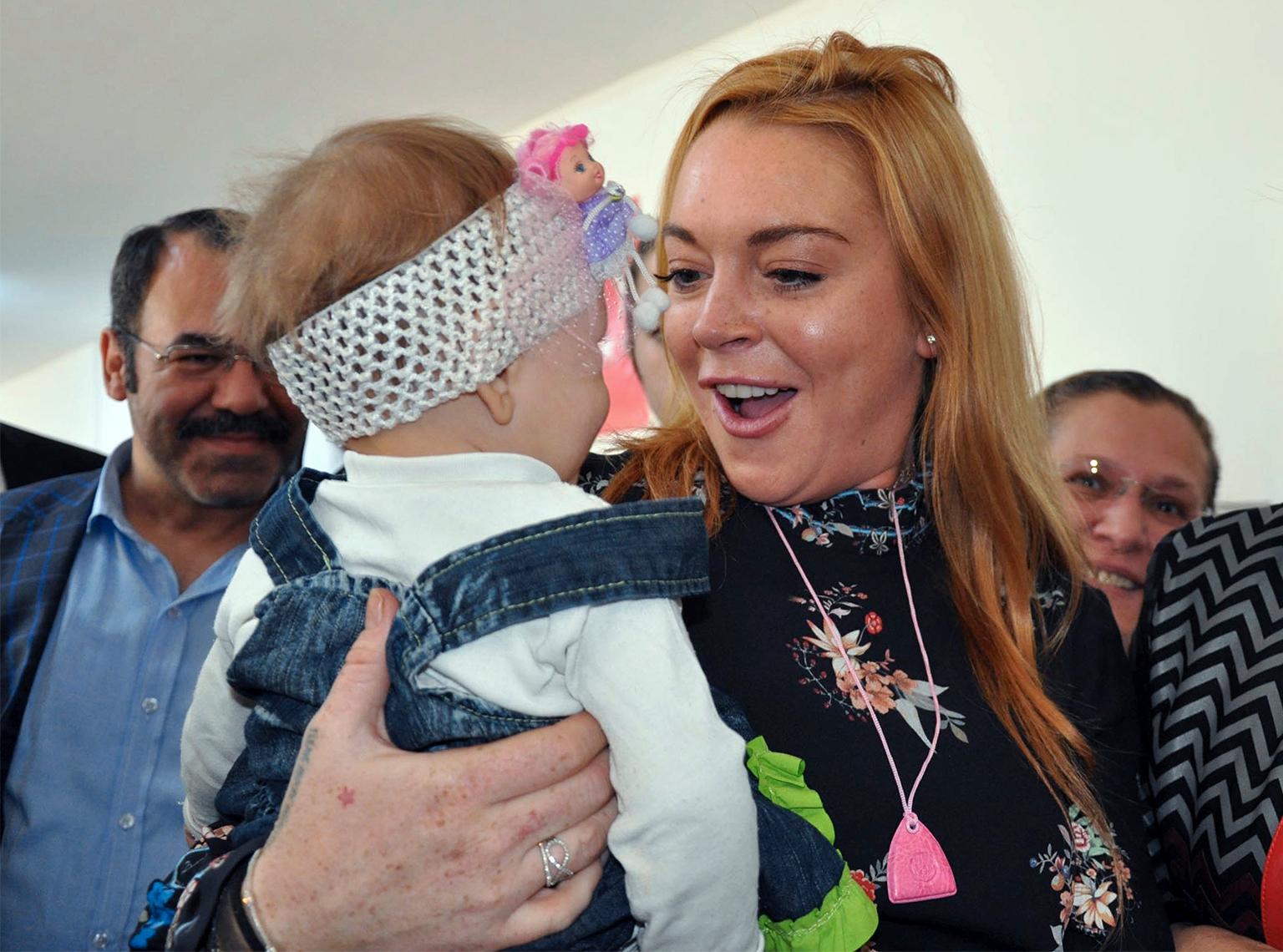Lindsay Lohan med ett syriskt flyktingbarn.