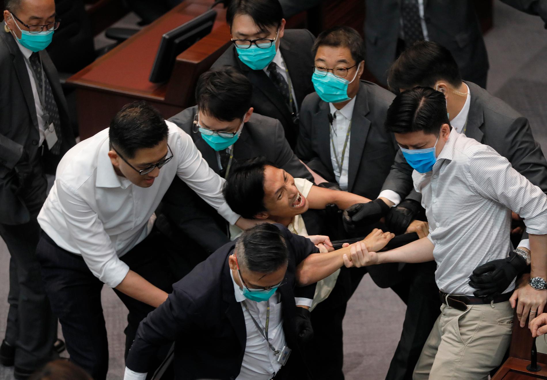 Den prodemokratiske ledamoten Chu Hoi Dick (i mitten) i handgemäng med säkerhetsvakter.