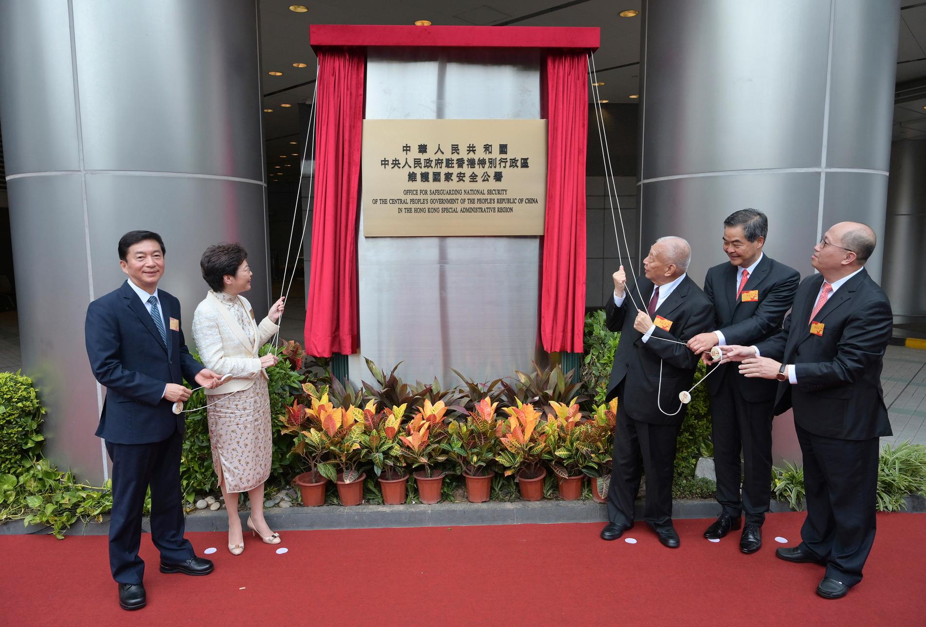 Regeringschefen Carrie Lam och Pekings representanter applåderar när Kinas nya agentkontor öppnar i det som nyligen var Metropark Hotel i Hongkong.