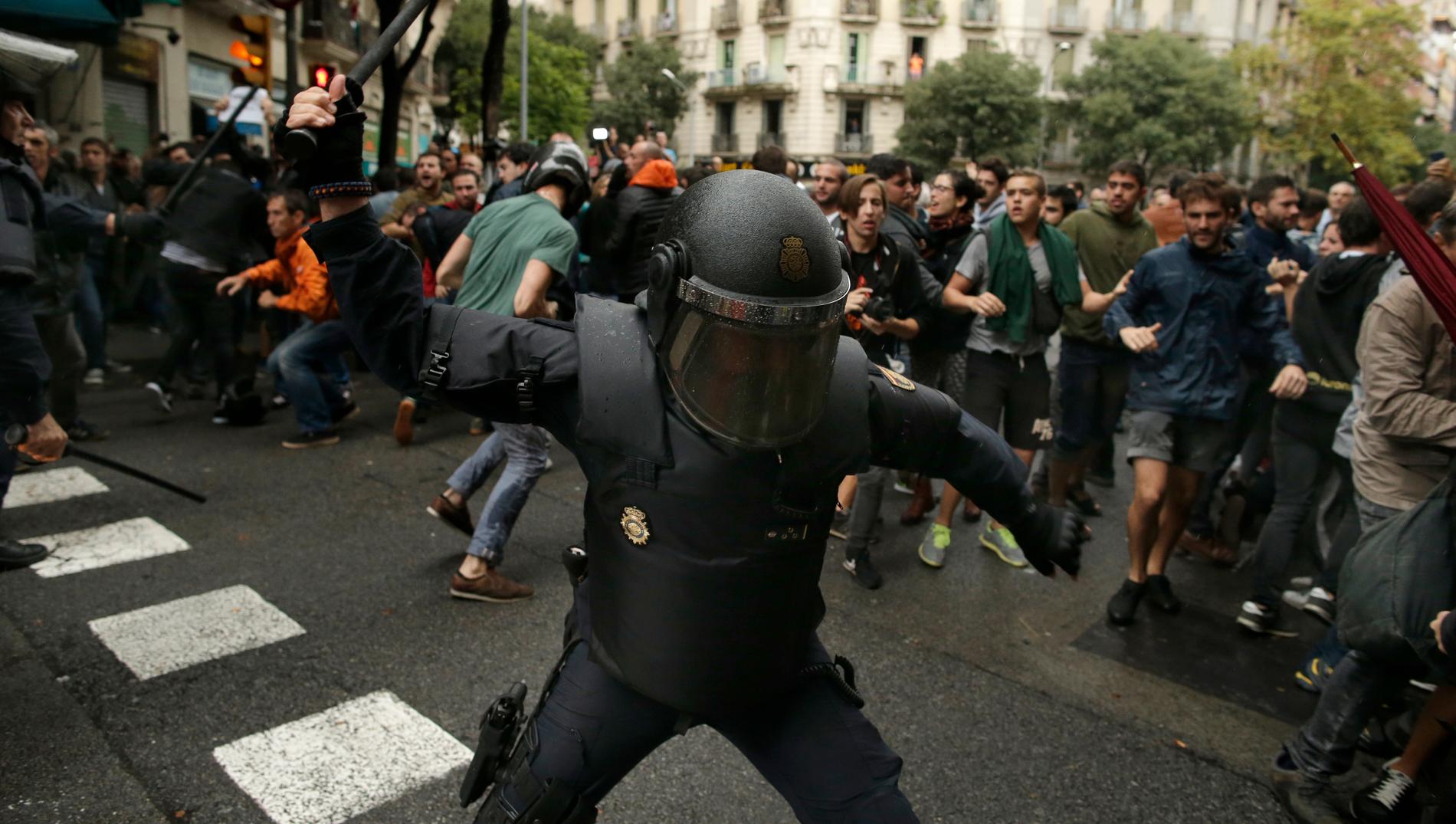 En spansk polis i närheten av en vallokal i Barcelona under valdagen.