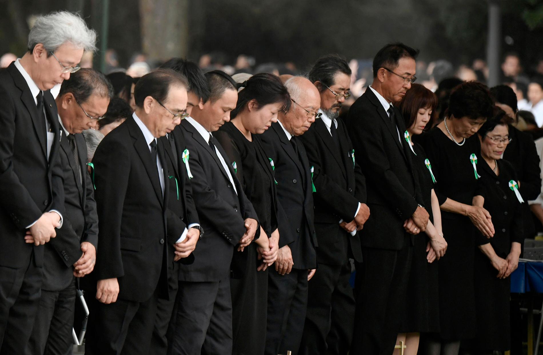 Folk hedrar atombombens offer i en tyst bön.