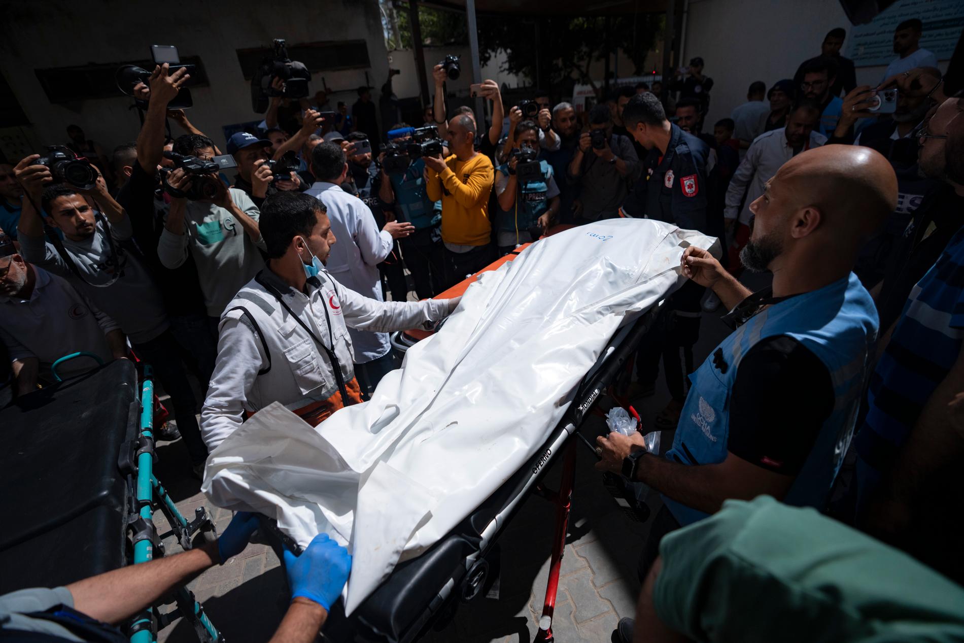 Biståndsarbetare från World Central Kitchen med kroppen av en av sina dödade kollegor vid ett bårhus i Rafah.