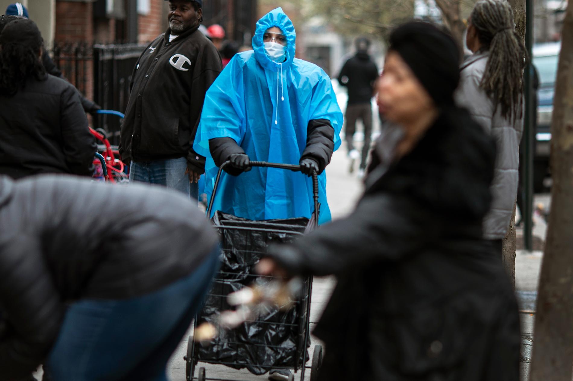 En kvinna i poncho och ansiktsmask i Brooklyn.