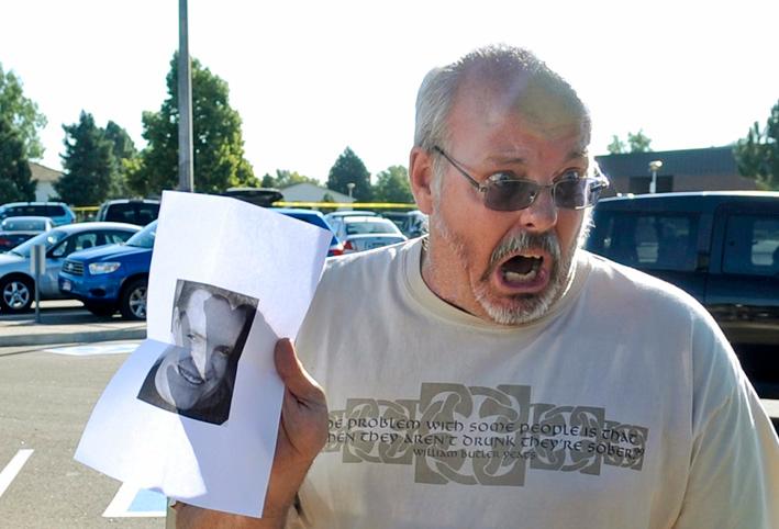 Tom Sullivan håller upp ett foto på sin son Alex, som är försvunnen efter massakern.