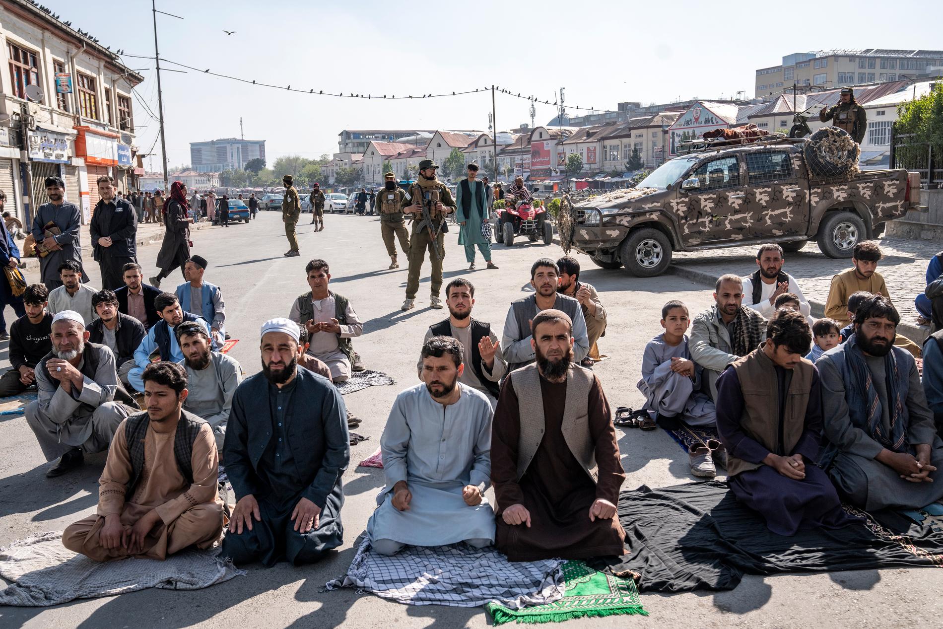 Talibaner håller vakt medan muslimer ber i Kabul, Afghanistan. 