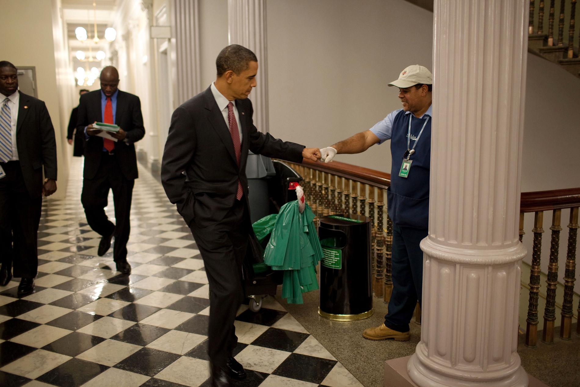 Obama gör en "fist-bump" med en vaktmästare på Eisenhower Executive Office Building.