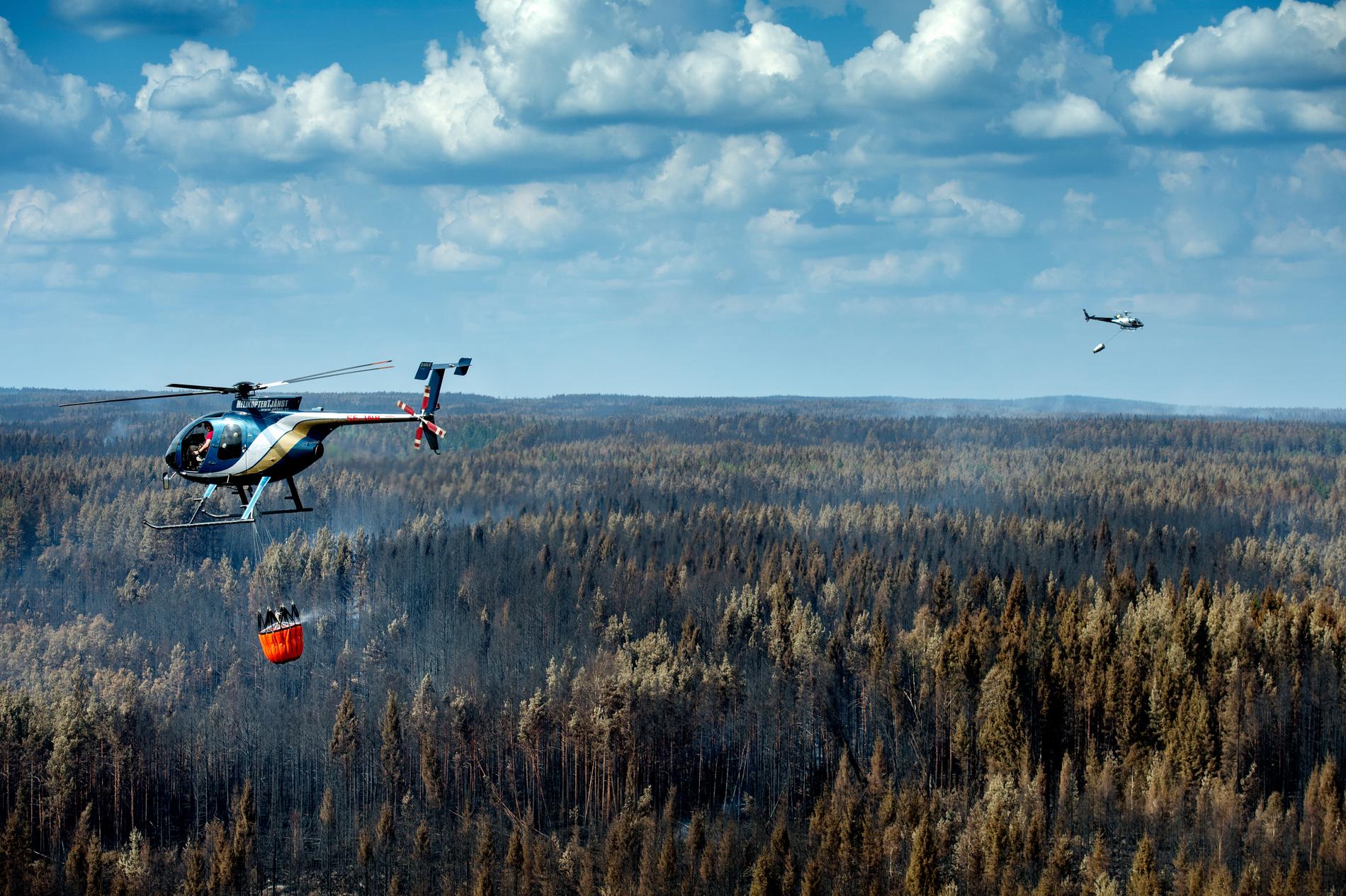 Helikoptrar vattenbombar den gigantiska skogsbrand som härjar kring Sala.