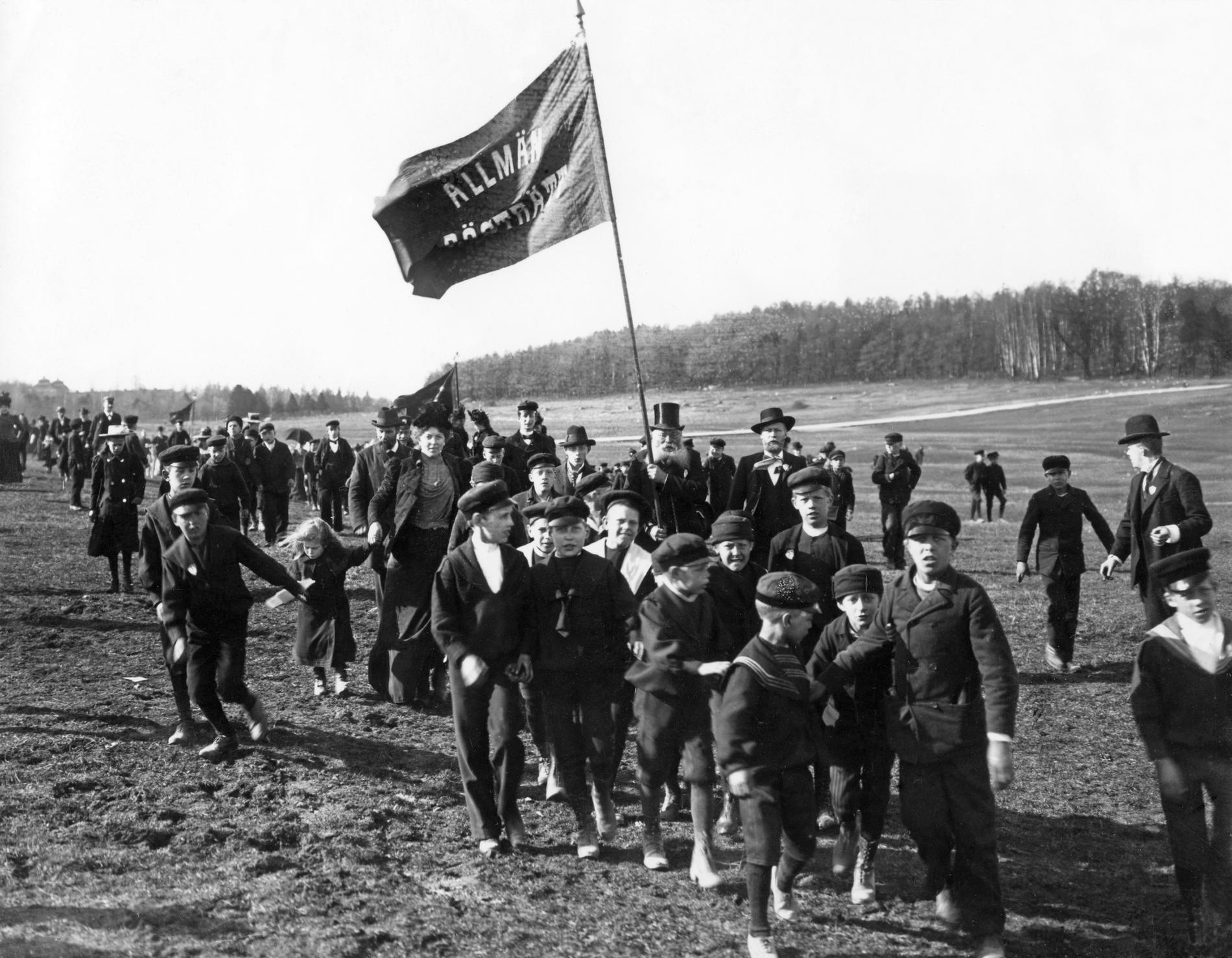 Förstamajdemonstration på Gärdet 1902 i Stockholm. Allmän rösträtt står det på fanan. Kampen för rösträtt var början på Sveriges väg mot det jämlikaste landet i modern tid, om man frågar vänstern.