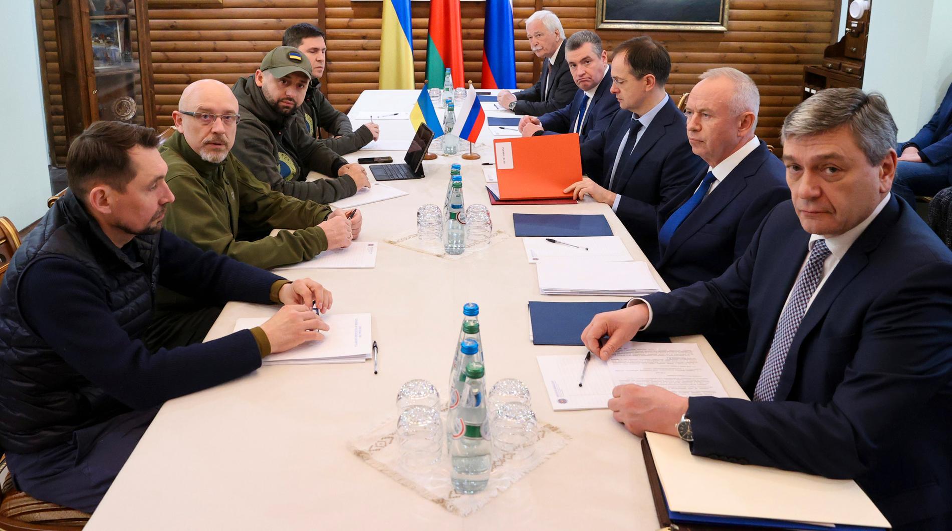 De ukrainska och ryska delegationerna inför sitt samtal på måndagen.