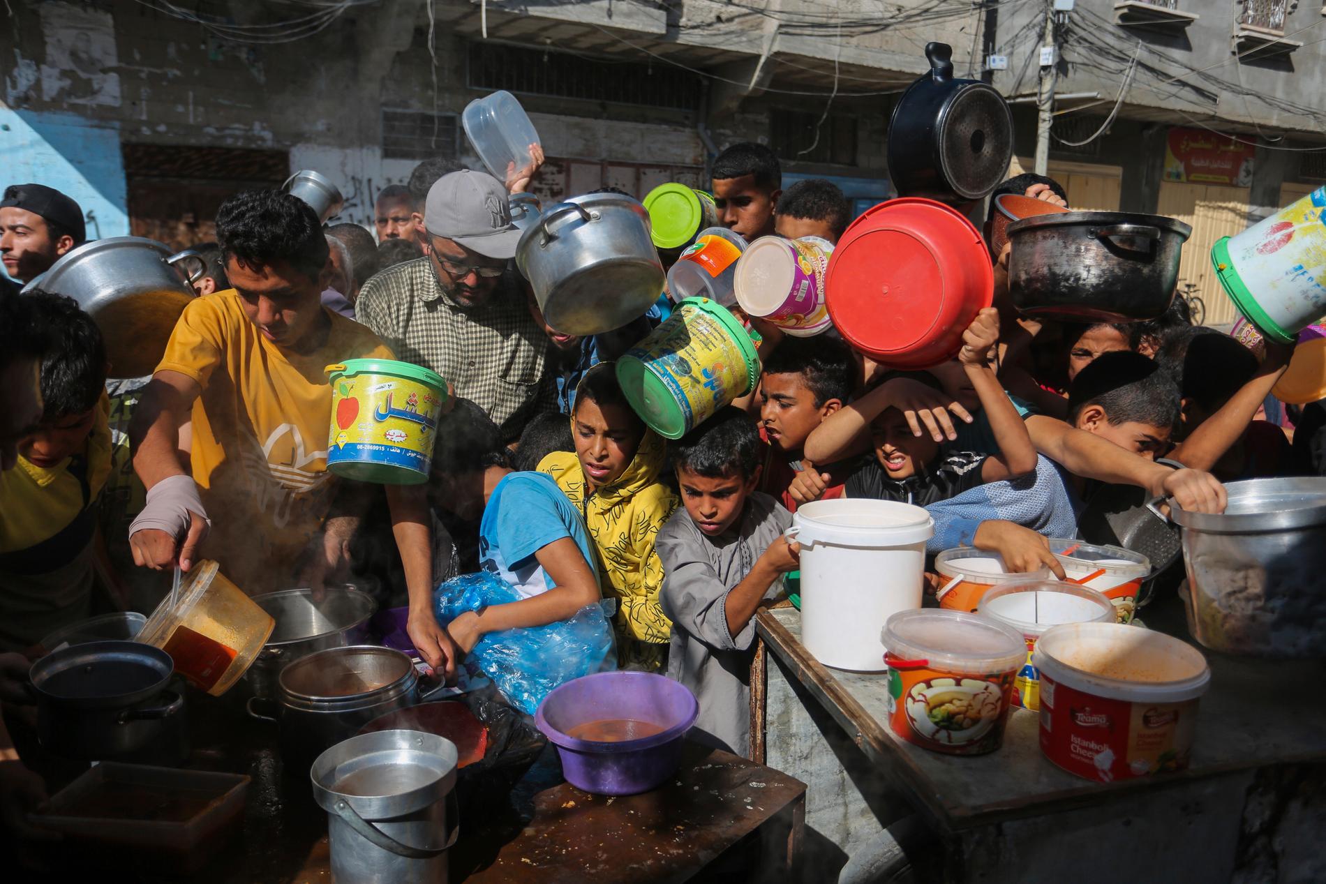 Människor väntar på utdelning av mat vid gränsövergången Rafah i södra Gaza. Bild från den 8 november.