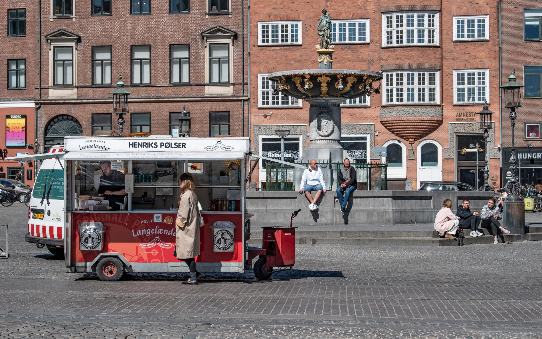 Henrik Rigtrup, pølseförsäljare på Strøget i Köpenhamn med en av få kunder vid lunchtid på tisdagen.