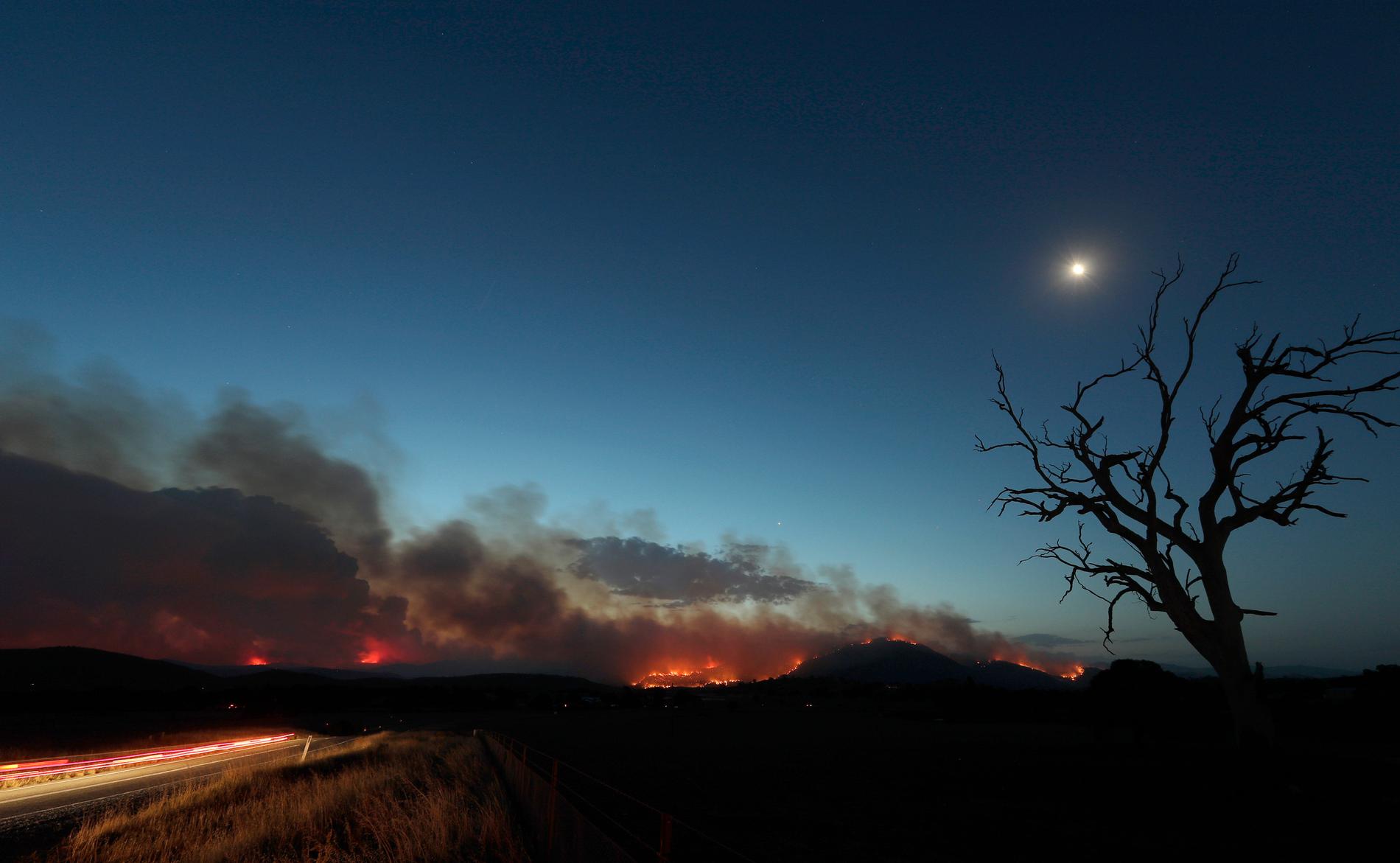 Clear Range-branden har vuxit i styrka, till följd av höga temperaturer. På bilden syns den söder om huvudstaden Canberra på fredagskvällen.