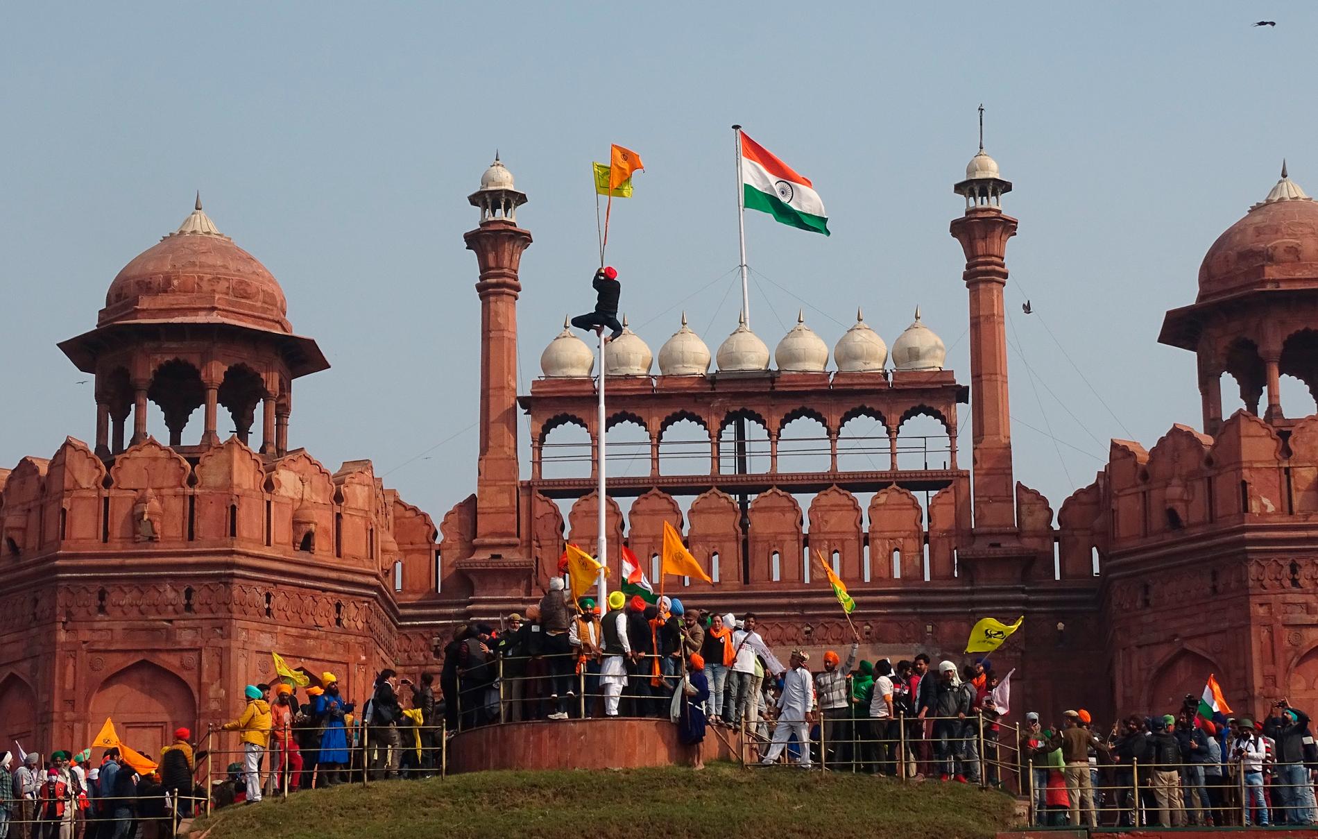 Demonstranter har forcerat polisens avspärrningar och tagit sig upp på det historiska röda fortet i New Delhi.