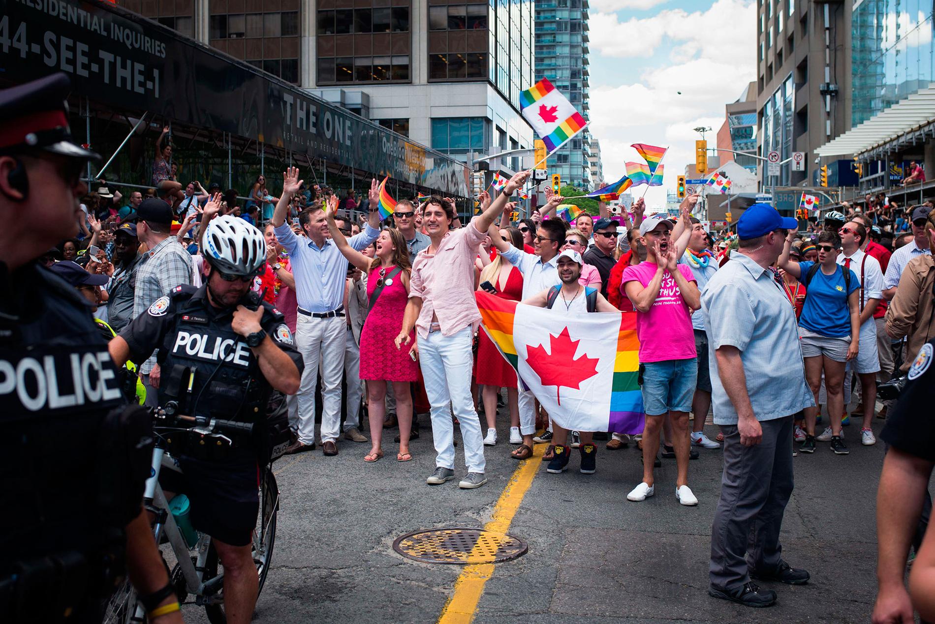 Kanadas premiärminister Justin Trudeau, ståendes i mitten, viftar med en regnbågsflagga under den årliga  Pride-festivalen i Toronto, Kanada, den 3 juli.